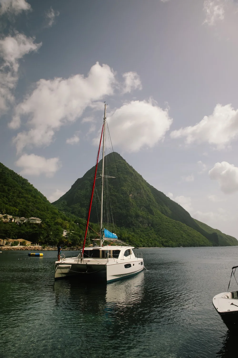 Catamaran anchored in a bay beneath a Piton